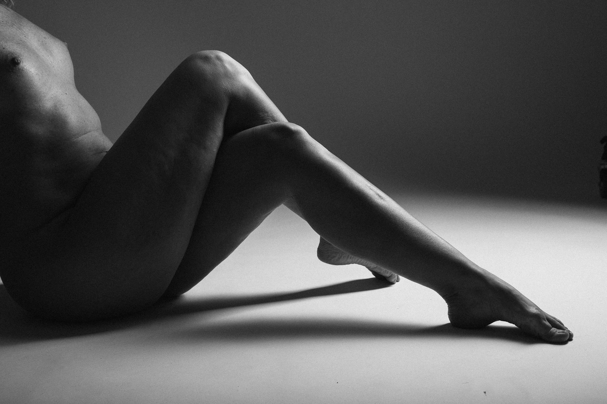 Čierno-biely umelecký akt zobrazujúci elegantne skrížené nohy. Ateliér Pezinok.