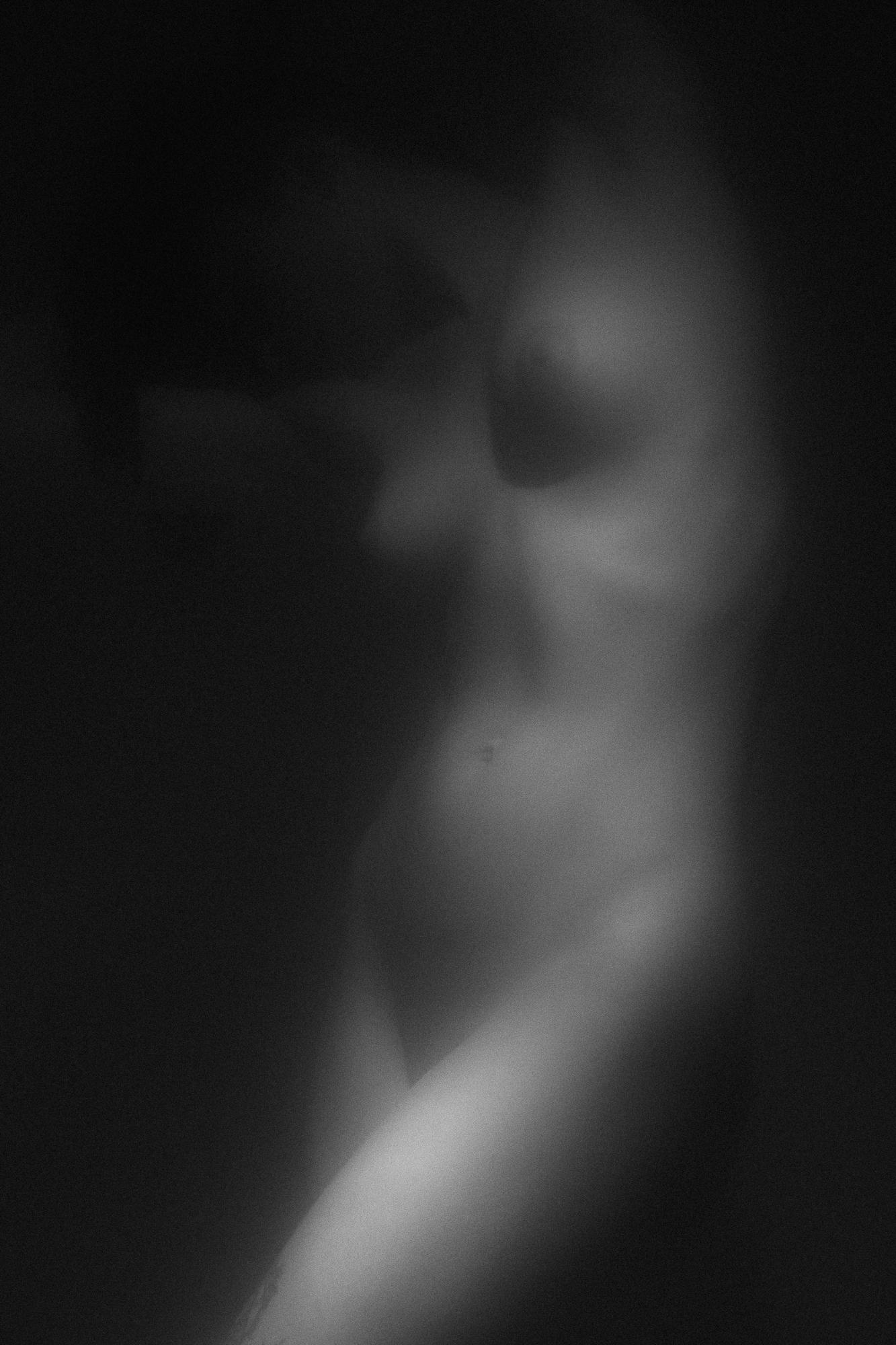 Čierno-biely umelecký akt zachytávajúci jemné krivky ženského tela v svetle a tieňoch, s dôrazom na jemnú kompozíciu a estetiku, Ateliér Pezinok.