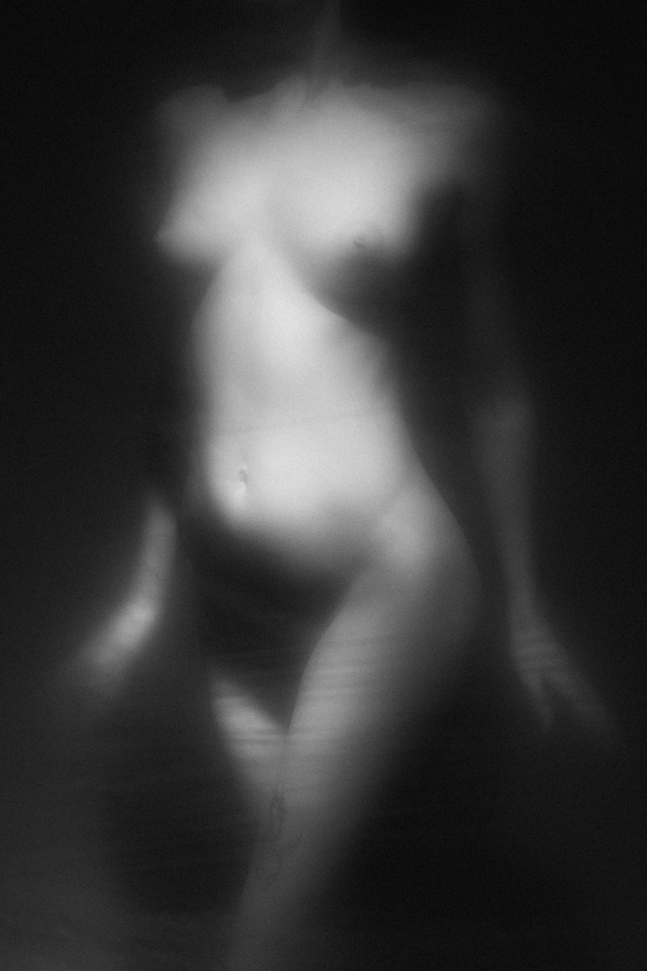 Čierno-biely umelecký akt zachytávajúci jemné krivky ženského tela s jemnou hrou svetiel a tieňov. Ateliér Pezinok.